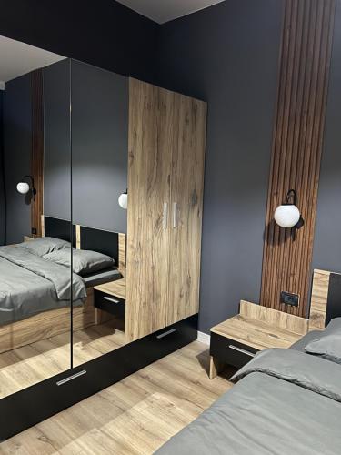 a bedroom with two beds and a large mirror at Peak Perspective 32nd Floor Apartment Spa&Fitness Access in Skopje