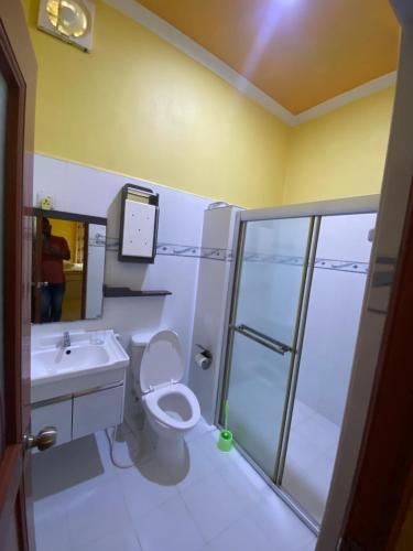 ein Bad mit einer Dusche, einem WC und einem Waschbecken in der Unterkunft Maavaharu - K.Huraa in Huraa
