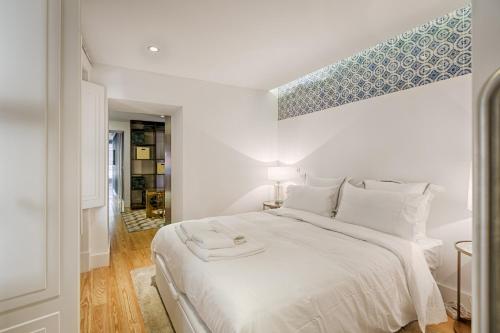a white bedroom with a large bed with a blue ceiling at Deco Gem in Santa Catarina in Lisbon