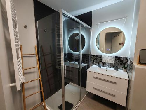une salle de bain avec une douche, un lavabo et un miroir dans l'établissement Pearl Beach - Rooftop Pool Seaside, à Villeneuve-Loubet