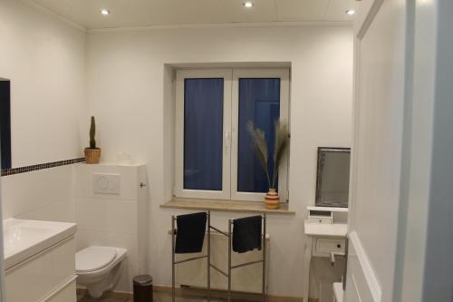 een witte badkamer met een toilet en een raam bij 3 Zimmer 6 Betten Renoviert in Koblenz
