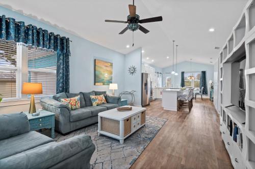 a living room with a couch and a ceiling fan at Blu Star Oasis Beach Htd Pool Pets Firepit in Saint Augustine