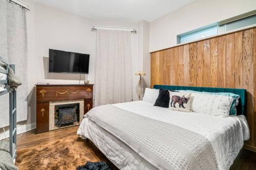 um quarto com uma cama com lareira e uma televisão de ecrã plano em The Village Inn by Dakota Gal Digs em Chicago