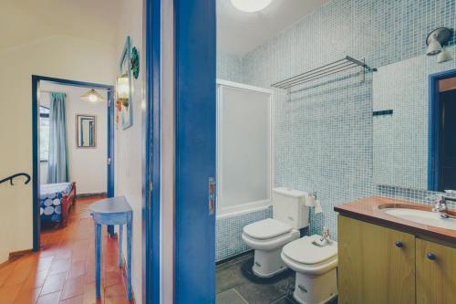 a blue bathroom with a toilet and a sink at Vila Mourisca in Armação de Pêra