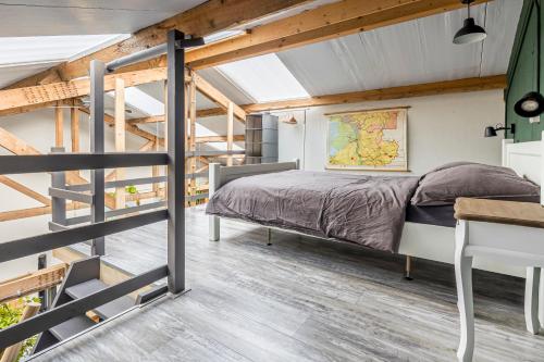 una camera da letto con un letto e una scrivania di Het Kamphuis, landelijk slapen a Heerhugowaard