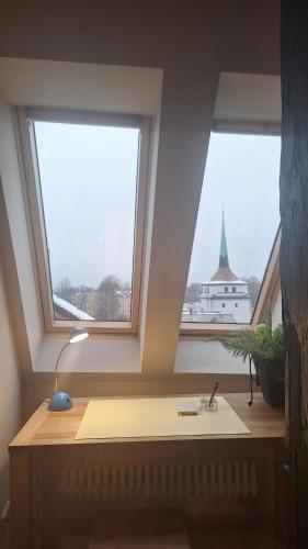 a desk with a lamp in a room with two windows at Stadtpalais Bellevue-Suite 3- Zimmer- Maisonettewohnung mit Dachterrasse maximal 4 Personen in Bautzen