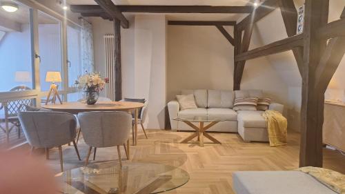uma sala de estar com um sofá e uma mesa em Stadtpalais Bellevue-Suite 3- Zimmer- Maisonettewohnung mit Dachterrasse maximal 4 Personen em Bautzen