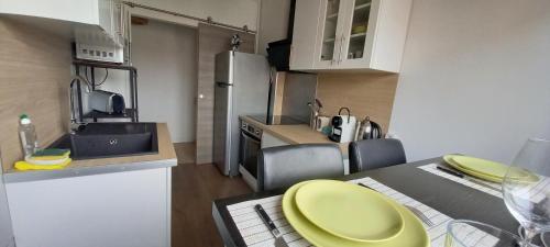 une cuisine avec une assiette jaune sur une table dans l'établissement NEW appartement proche gare et centre-ville, à Colmar