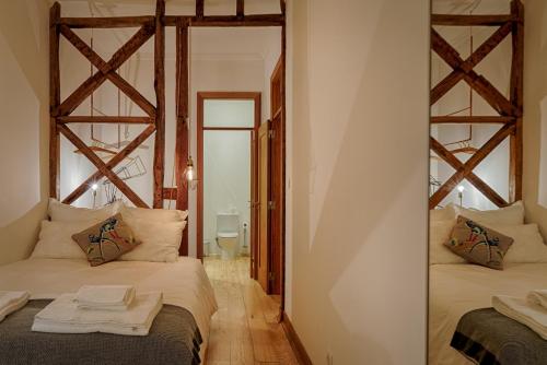 a bedroom with two beds and a mirror at Master Historical Gem in Chiado in Lisbon