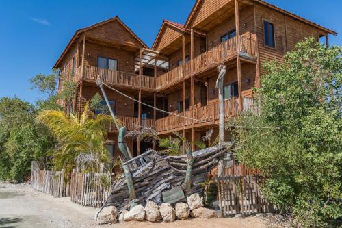a wooden house with a balcony on a beach at Krak-Inn Holbox - Pet Friendly in Holbox Island