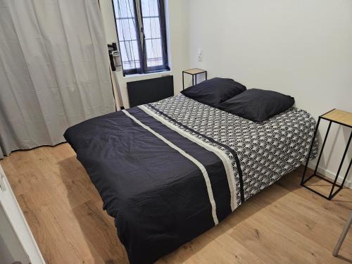 - une chambre dotée d'un grand lit avec des draps noirs et blancs dans l'établissement T2 chaleureux, calme et entièrement rénové., à Béziers