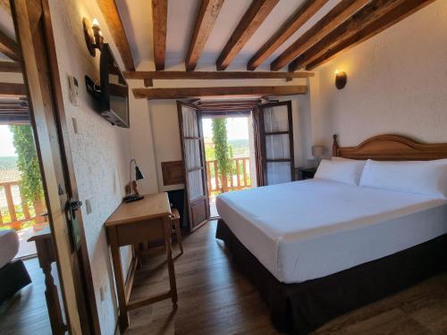 a bedroom with a large white bed and a window at Hotel Labranza in San Martín de Valdeiglesias