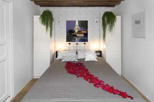 Una cama con un montón de rosas rojas. en My Nest Inn Paris Panthéon - 31m2 - 2min du Panthéon en París
