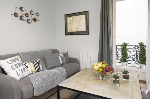 sala de estar con sofá y mesa de centro en My Nest Inn Paris Panthéon - 31m2 - 2min du Panthéon en París