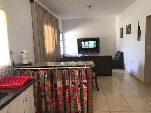 a kitchen and living room with a television and curtains at Chácara lazer in Votorantim