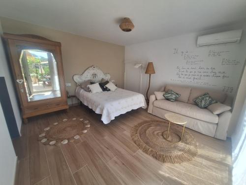 ein Wohnzimmer mit einem Sofa und einem Tisch in der Unterkunft Au Jardin d'Armand in Sant Pere de Ribes