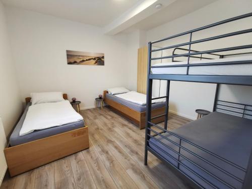 two bunk beds in a room with wooden floors at SOVA Pension Fuldatal in Fuldatal