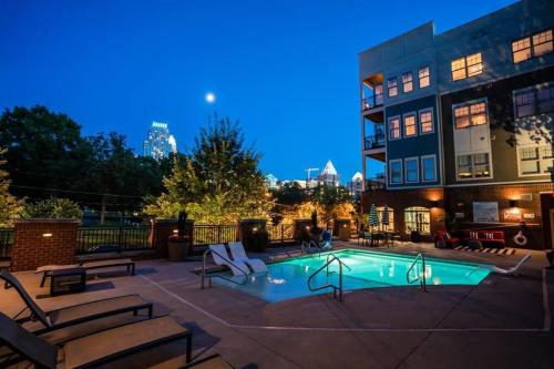 a swimming pool with benches and a building at 1Br Uptown, Pool, Wine, near Convention Center_311 in Charlotte