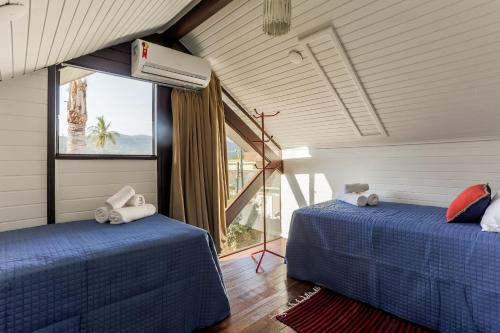 two beds in a room with a window at Casa aconchegante na Lagoa da Conceição #LC02 in Florianópolis