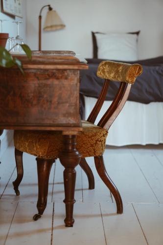 an old wooden desk with a chair and a bed at Axatorpsgården in Trelleborg