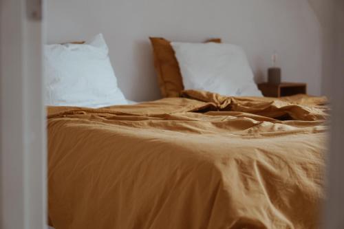 a bed with brown sheets and pillows in a bedroom at Axatorpsgården in Trelleborg