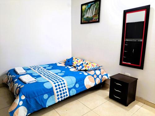 a bedroom with a bed and a mirror at Tu hogar lejos de casa. in Garzón