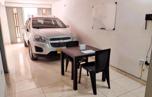 un coche aparcado en un garaje con una mesa y sillas en Tu hogar lejos de casa., en Garzón