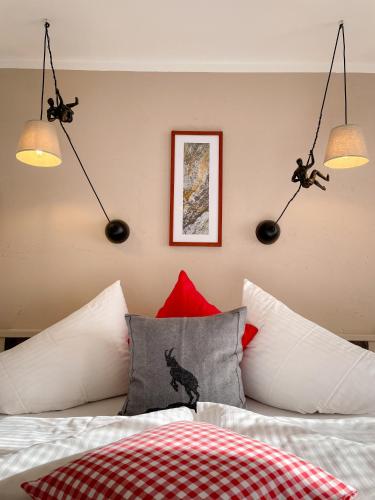 ein Schlafzimmer mit einem Bett mit roten und weißen Kissen in der Unterkunft TENNE Arlberg - Boutique Hotel & Restaurant in Sankt Anton am Arlberg