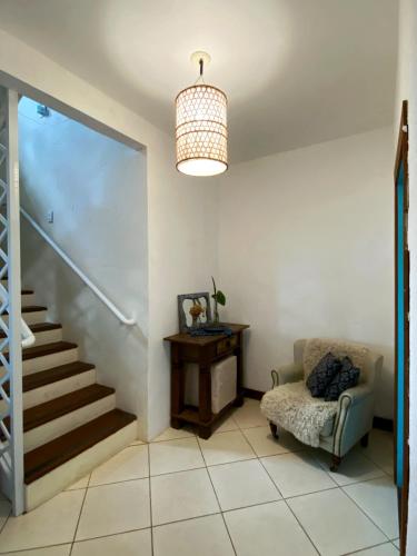 a living room with a staircase and a chair at Solar das Pétalas Guest House in Florianópolis