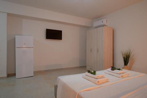 um quarto com um frigorífico e uma cama com toalhas em Appartement pour deux personnes em Patitiri
