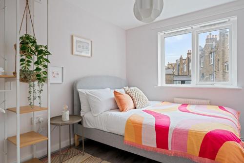 a bedroom with a bed and a window at Stylish 2 Bed Flat in Vibrant East London in London