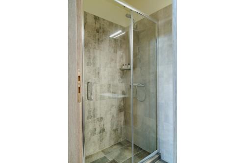 a shower with a glass door in a bathroom at Appartement pour deux personnes in Patitiri