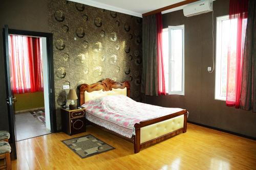een slaapkamer met een bed en een muur met ramen bij Guesthouse Lasha in Khoni