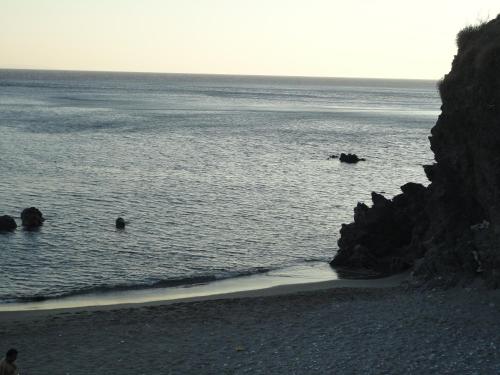 a group of people in the water on a beach at Archontika Apartments in Kerames