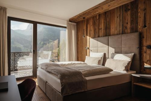 a bedroom with a large bed and a large window at Luxury Chalet Lefiro in Santa Cristina in Val Gardena