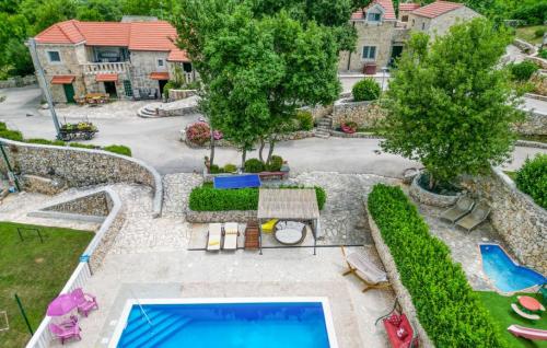 eine Luftansicht auf einen Hinterhof mit Pool und Bäumen in der Unterkunft Villa Brkic with large private pool and playground in Brkići