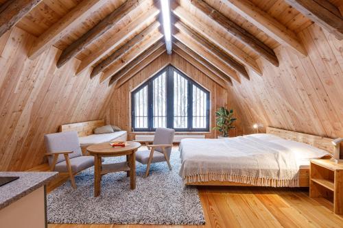 a bedroom in a log cabin with a bed and a table at Gonna Dom w Górach in Gniewoszów