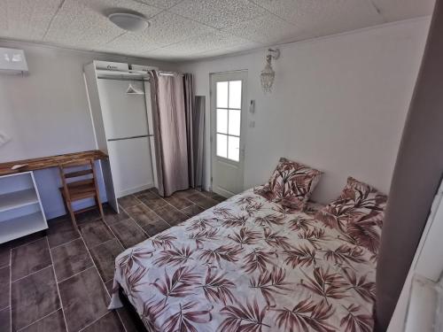 une chambre avec un lit, une table et une fenêtre dans l'établissement Calanques Prado Stade et Parking, à Marseille