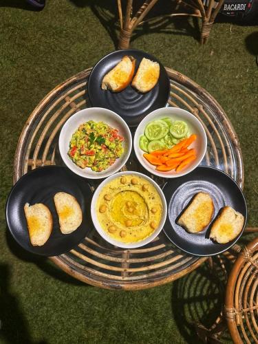 a tray with four plates of food on a table at SOLS Backyard in Arambol