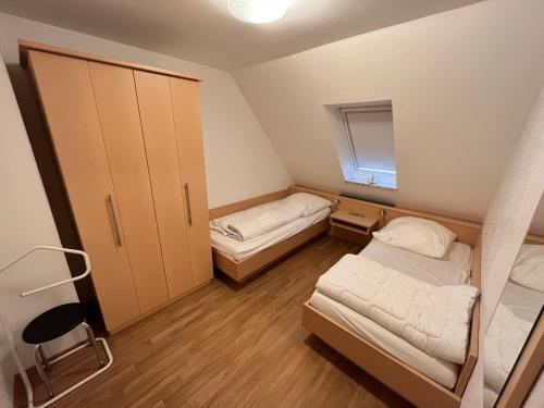 a small room with two beds and a window at Haus Delphin - Ferienwohnung 2 in Norderney