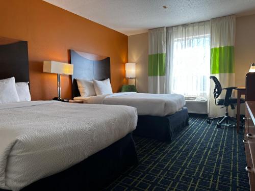 a hotel room with two beds and a window at SureStay Plus by Best Western Fenton in Fenton