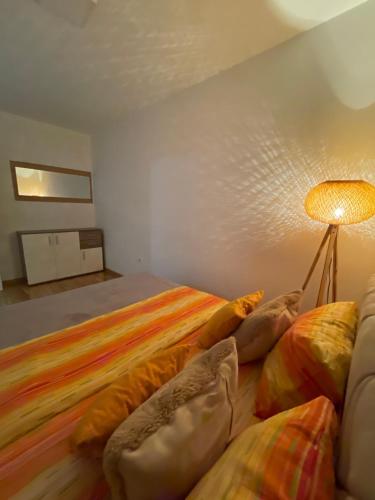a bedroom with a bed with pillows and a lamp at Apartman Royal 4 in Doboj