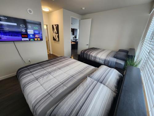 a room with two beds and a flat screen tv at Amazing 2Bdr Home Must See DTLA in Los Angeles