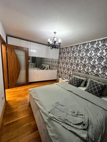 a bedroom with a large bed and a mirror at Debo Apartament in Lugoj