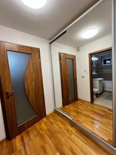 a room with a glass door and a mirror at Debo Apartament in Lugoj