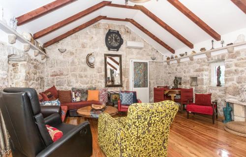 a living room filled with furniture and a stone wall at Villa Brkic with large private pool and playground in Brkići