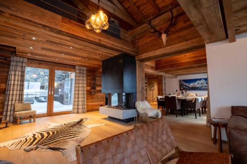 a living room with a fireplace and a dining room at Chalet Chardon Bleu in Méribel