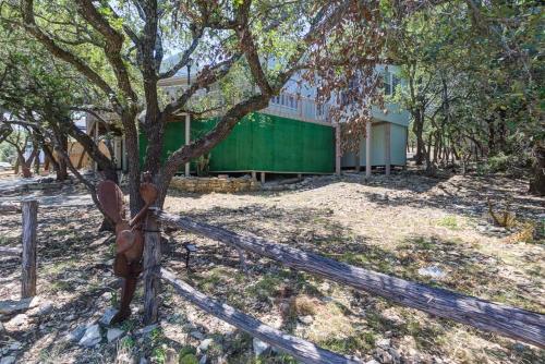 a fence with a tree in front of a building at Lake Hm Hideaway - Boat Rental! in Canyon Lake