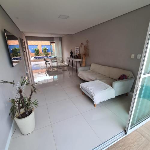 Casa com piscina a 800 metros da praia de Buraquinho في لورو دي فريتاس: غرفة معيشة مع أريكة وطاولة