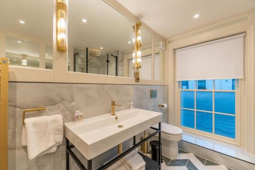 bagno con lavandino, servizi igienici e specchio di The Royal Albion a Broadstairs